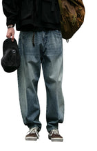 Load image into Gallery viewer, SHADOW FASHION CLOTHING men's loose-fit denim harem pants in a vintage blue wash, styled for a casual streetwear look.
